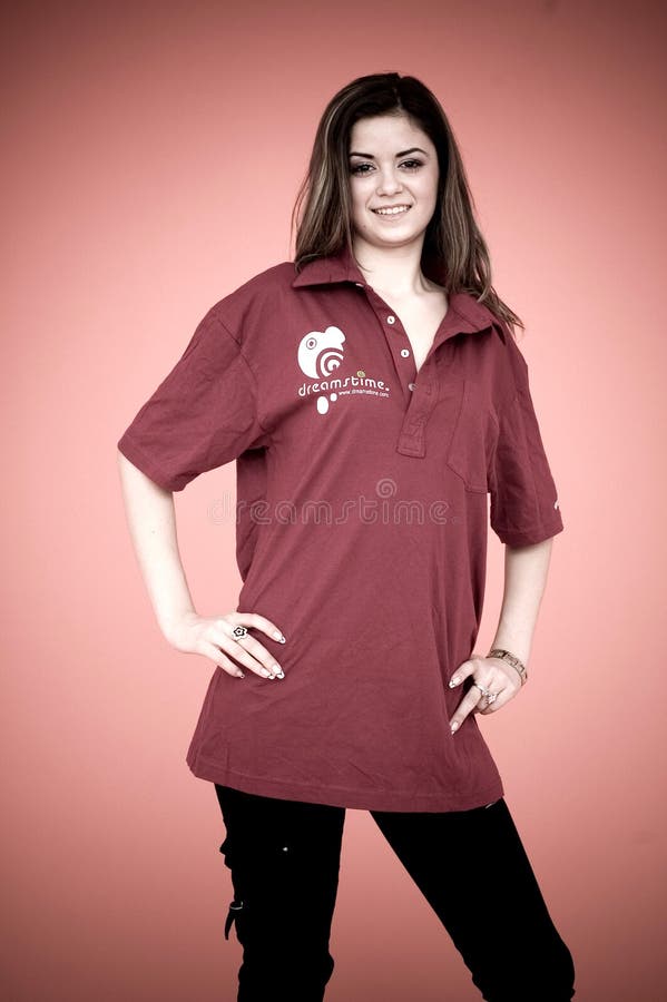 A view of a pretty young girl with hands on hips, wearing a maroon pullover shirt with the Dreamstime name and logo on it. Modified colors. A view of a pretty young girl with hands on hips, wearing a maroon pullover shirt with the Dreamstime name and logo on it. Modified colors.