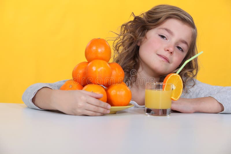Young girl drinking orange juice stock image