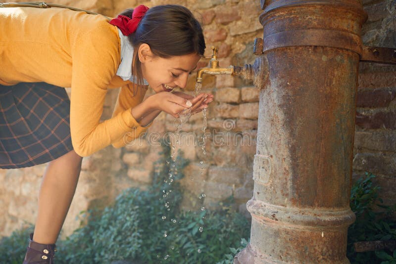 Young girl drinks from a drinking fountain stock photo Young girl drinks from a drinking fountain stock photo