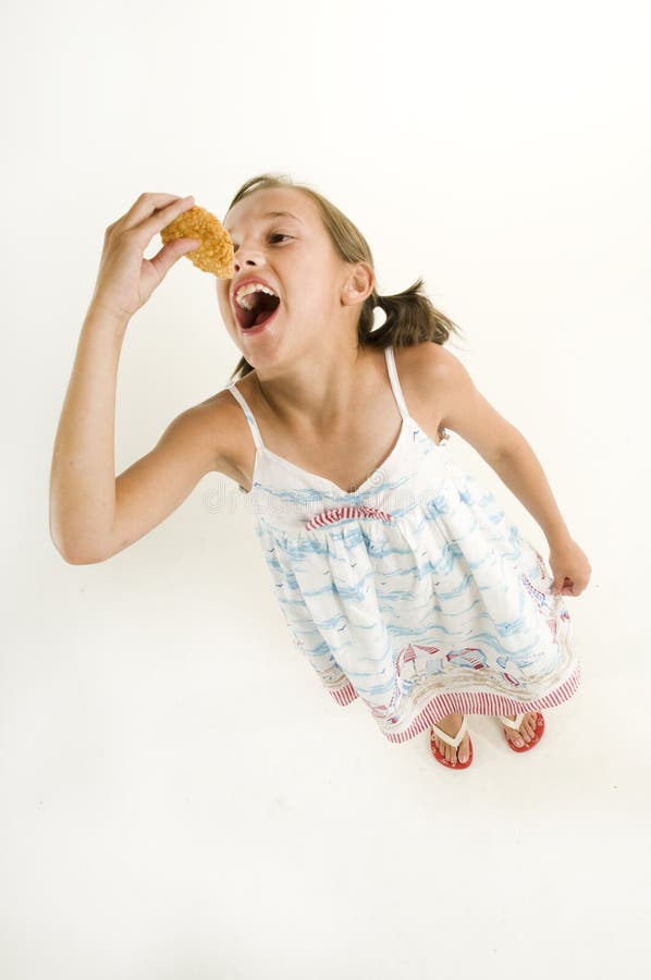 Young girl eating a chicken finger