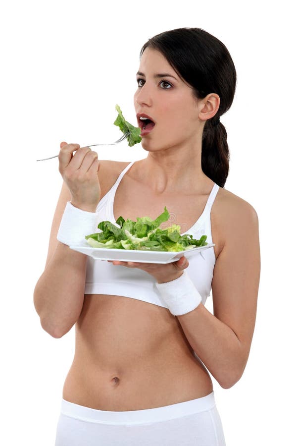 Young girl eating salad stock image