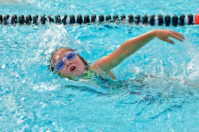 A young girl swimming freestyle in a competition. 8 years old. A young girl swimming freestyle in a competition. 8 years old.