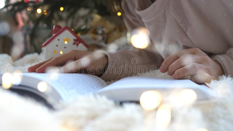 young-girl-in-front-of-christmas-tree-reading-book-new-year