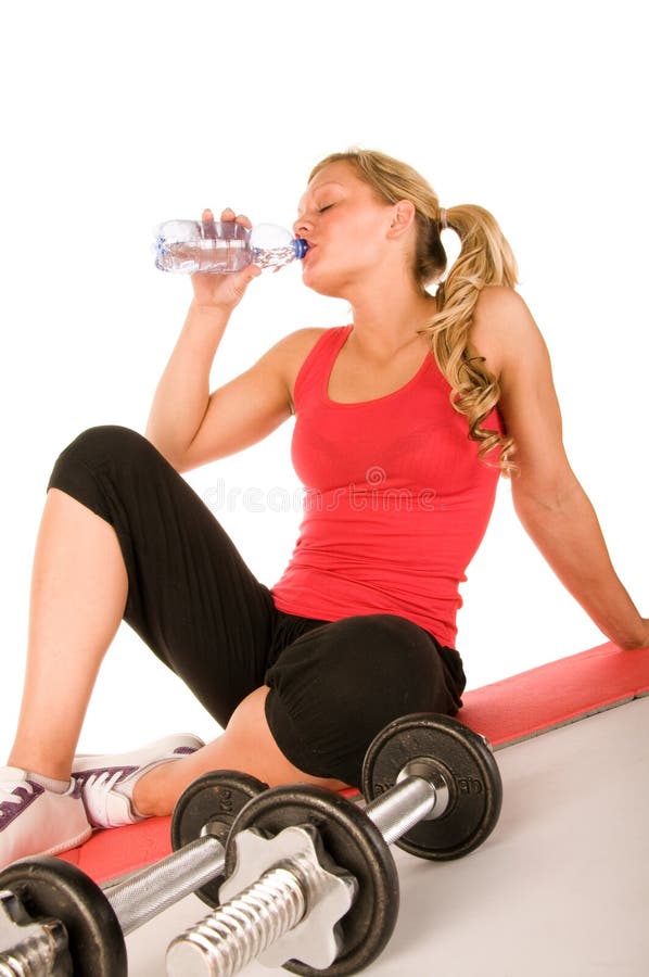 Young girl at the gym drinking water
