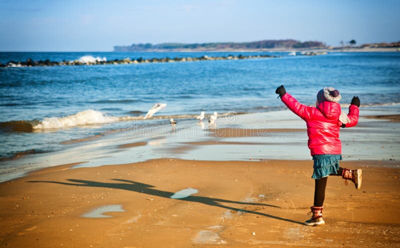 Young girl having fun on winter Baltic beach stock photography Young girl having fun on winter Baltic beach stock photography