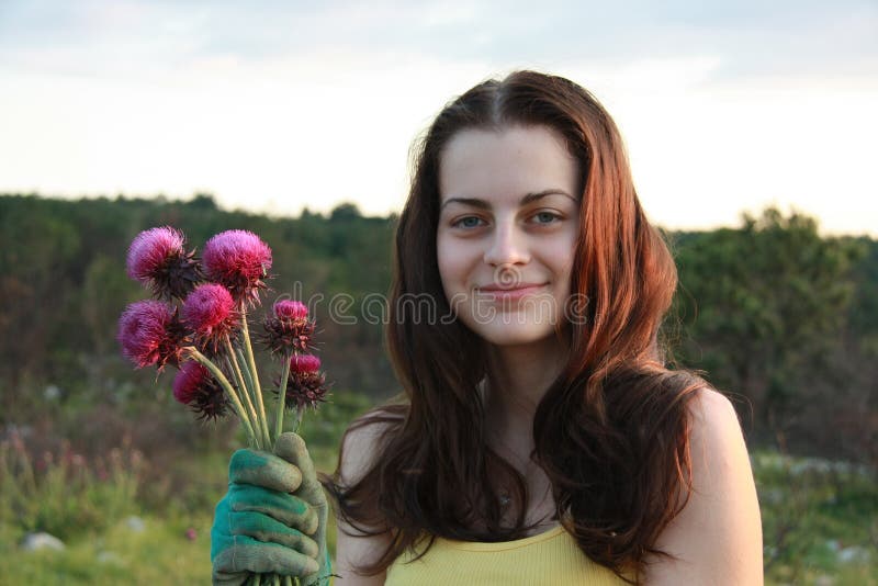 A young girl holding a flower - milk thistle, bouquet