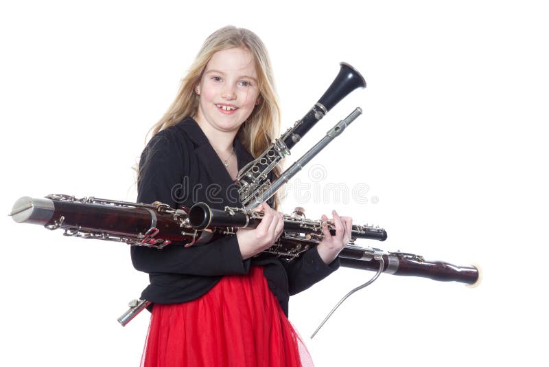 Young girl holds woodwind instruments in studio