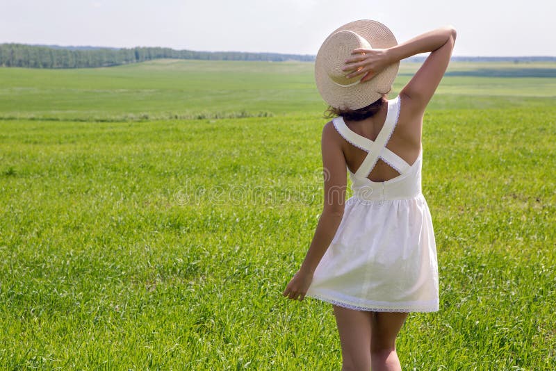 Young girl with long dark hair standing on a green field royalty free stock photo Young girl with long dark hair standing on a green field royalty free stock photo