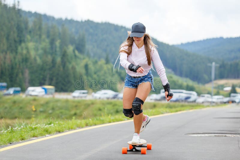 Young Girl Longboarding on Road Stock - Image kneepads, asphalt: 144884142