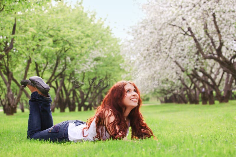 Young girl lying on green grass