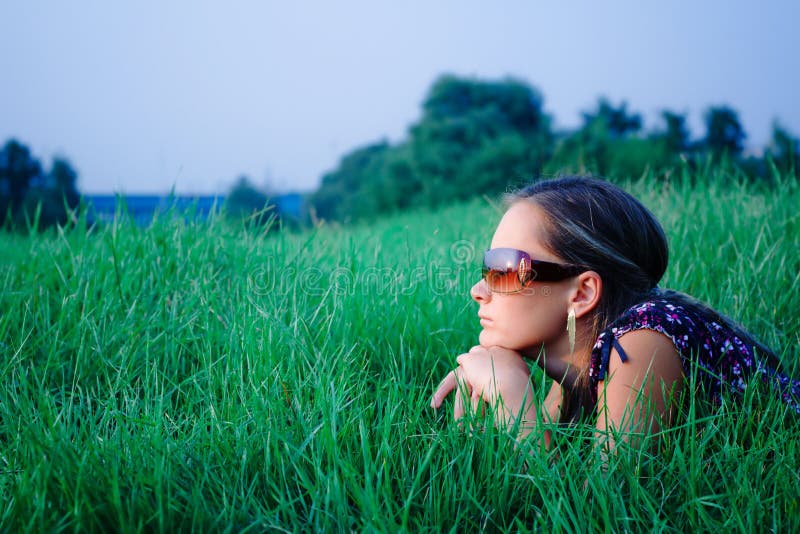 Young girl lying in green grass