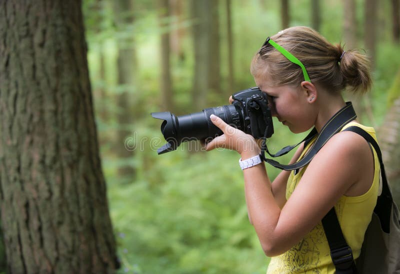 Dívka hledá koryto objektiv a udělat obrázek s dslr fotoaparát.