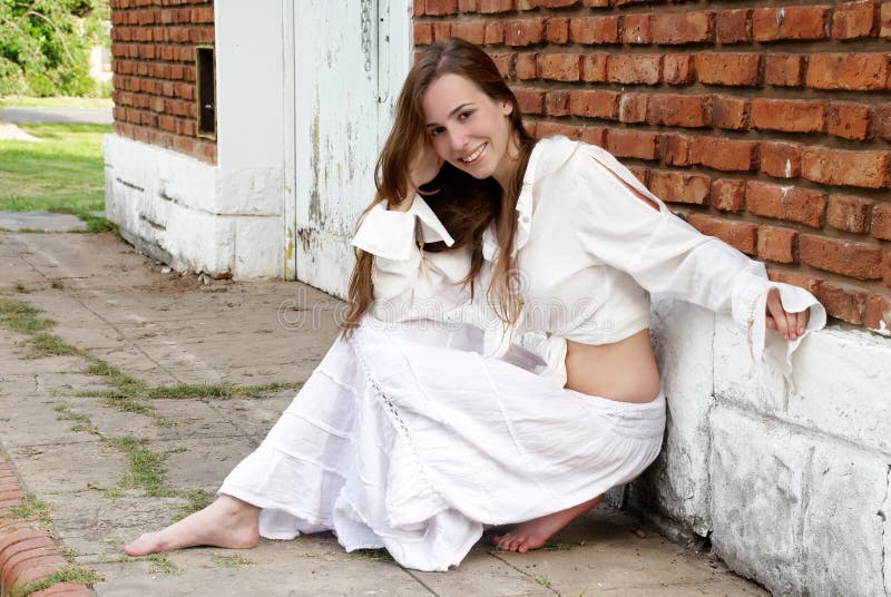 The young girl near a brick wall