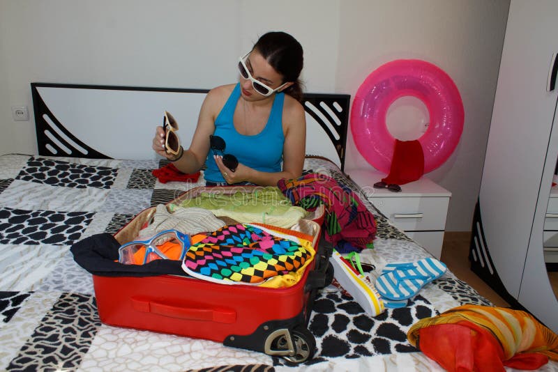 Young Girl packing suitcase on bed at home royalty free stock photo Young Girl packing suitcase on bed at home royalty free stock photo