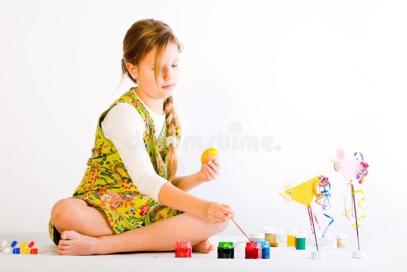 Young girl painting eggs