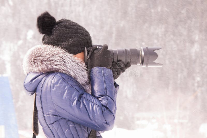 Young girl photographed in the winter in a snow storm on a SLR camera with telephoto lens