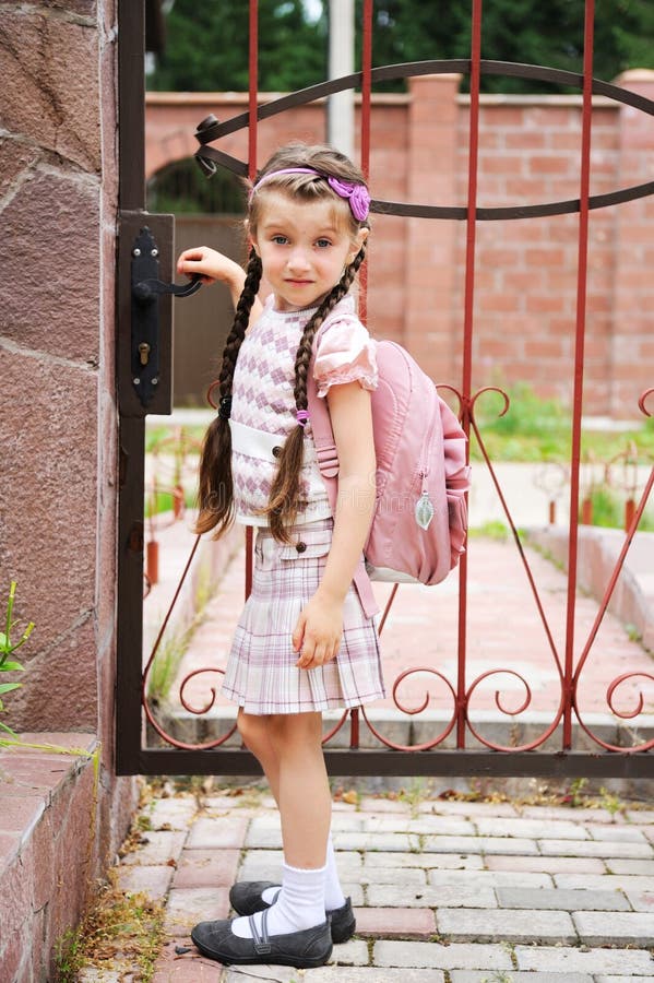 Young girl with pink bagpack leaves for school