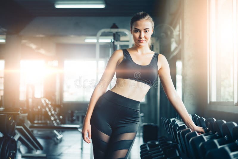 Young girl playing dumbbell to exercise in fitness.Slim girl lifts heavy dumbbell while training in the gym. Sports concept fat b royalty free stock photo Young girl playing dumbbell to exercise in fitness.Slim girl lifts heavy dumbbell while training in the gym. Sports concept fat b royalty free stock photo