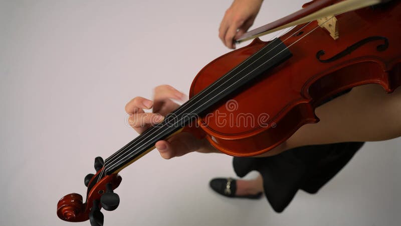 Young girl playing violin, view from above. The hand slides to the front of the violin