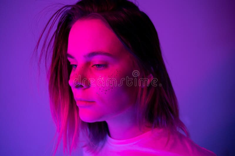 Young Girl Portrait In Neon Pink And Violet Lights With Glitter Freckles On Face Clubber Night 