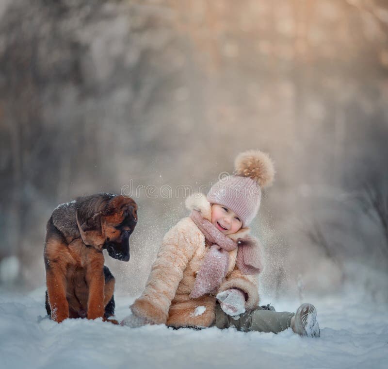 Giovane ragazza ritratto con il cucciolo di pastore tedesco sotto la neve in inverno parco.