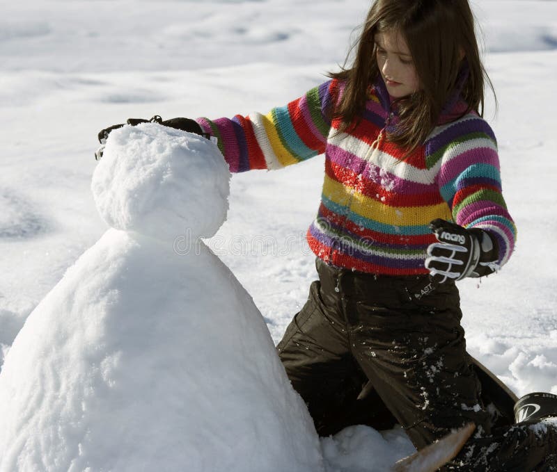 Young girl posing with her snowman