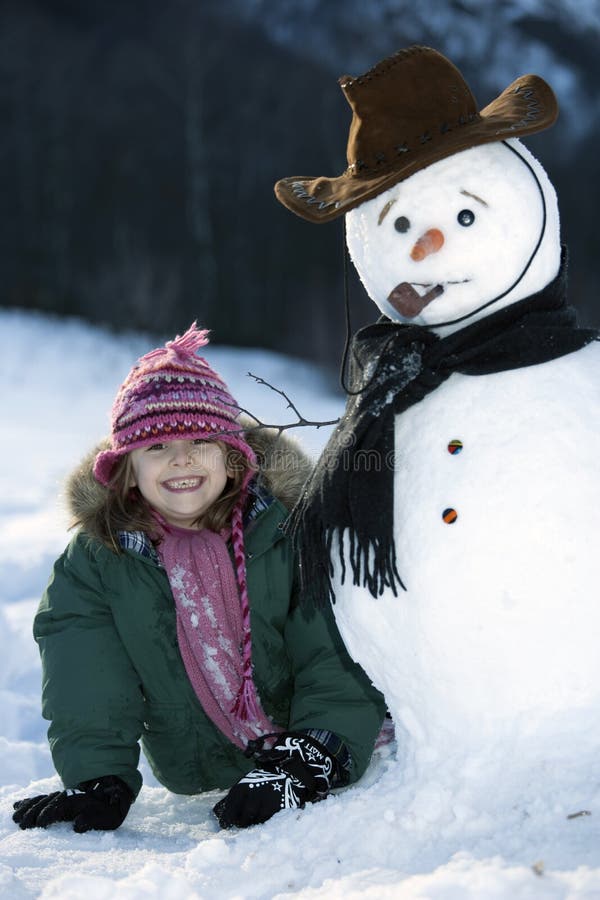 Young girl posing with her snowman