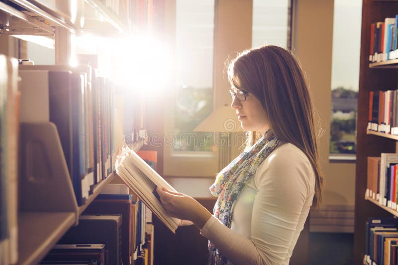 Young girl reading book at library over beautiful sunshine