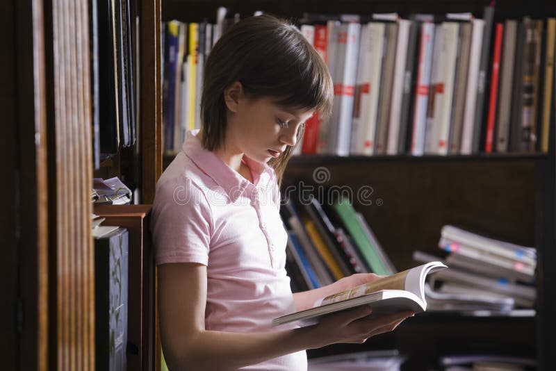 Young Girl Reading Book In Library