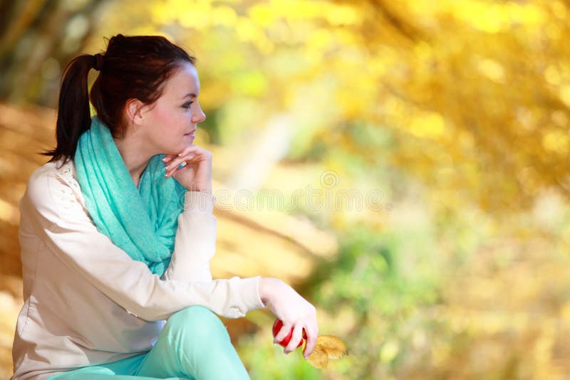 Young girl relaxing in autumnal park. Fall lifestyle concept.