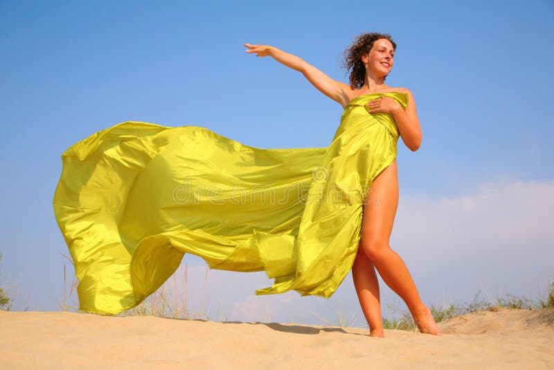 Young girl on sand in yellow fabric shawl