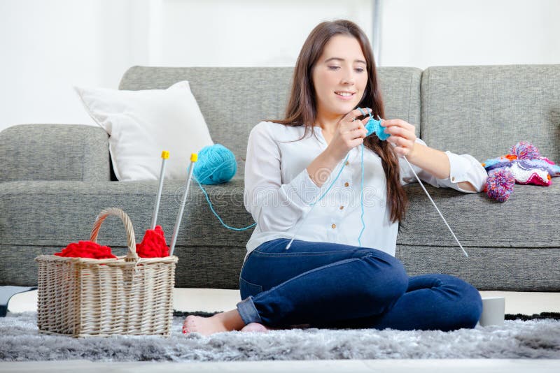 Young girl sat on floor knitting stock photos