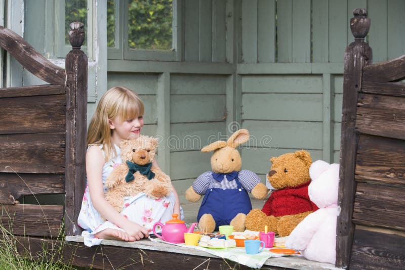 Young girl in shed playing tea and smiling