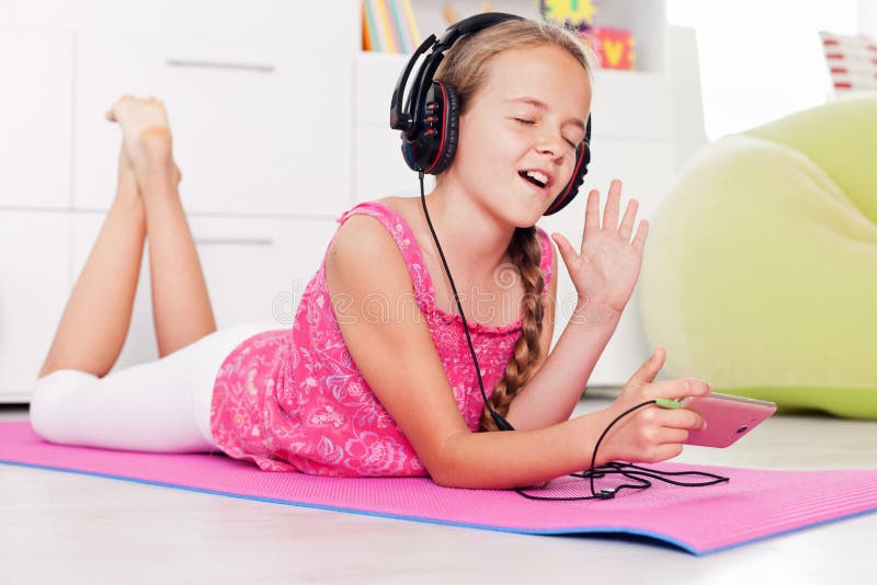 Young girl singing a tune listening to music on her phone stock photography Young girl singing a tune listening to music on her phone stock photography