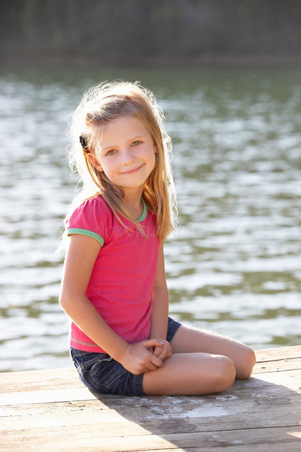 Young girl sitting by lake stock photo. Image of peaceful - 21097930