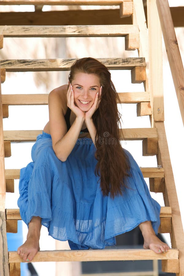 Young girl sitting on wooden stairs