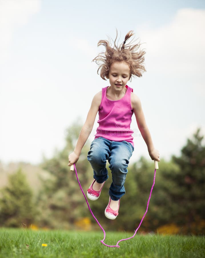 Young girl skipping in park