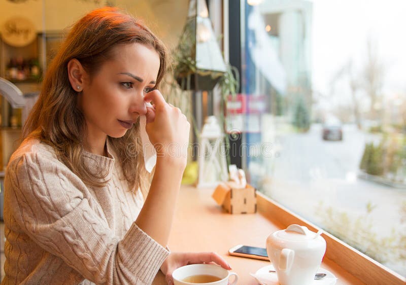 Crying young woman in cafeteria stock photography Crying young woman in cafeteria stock photography