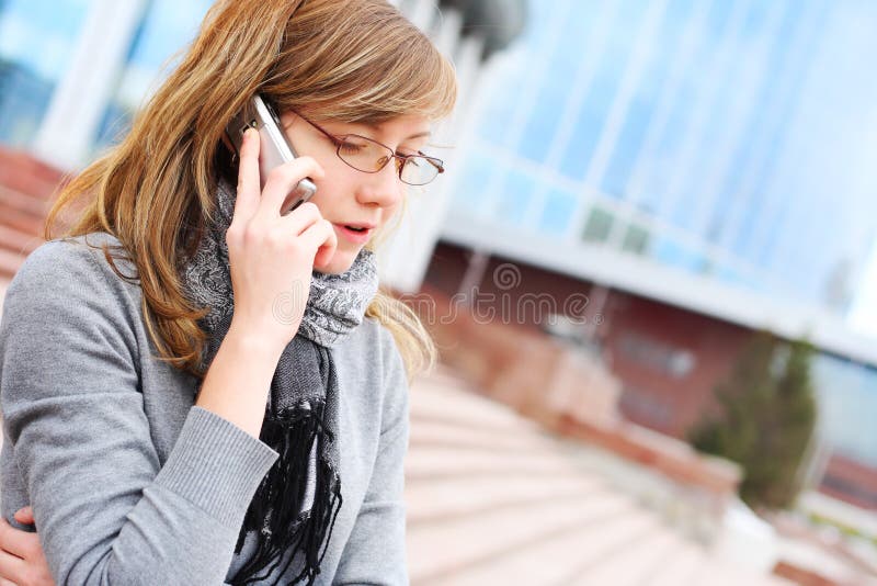 The young girl speaks by mobile phone. Business