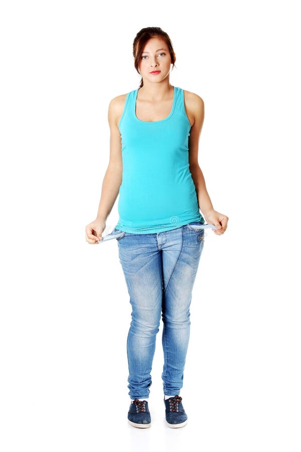 Young Girl Standing And Showing Her Empty Pockets. Stock Photo Image
