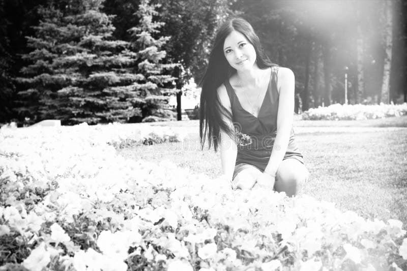Young girl, student, sits near the flowers in the Park stock photos Young girl, student, sits near the flowers in the Park stock photos