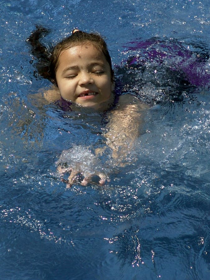 Isolated young girl swimming in a swimming pool. Isolated young girl swimming in a swimming pool