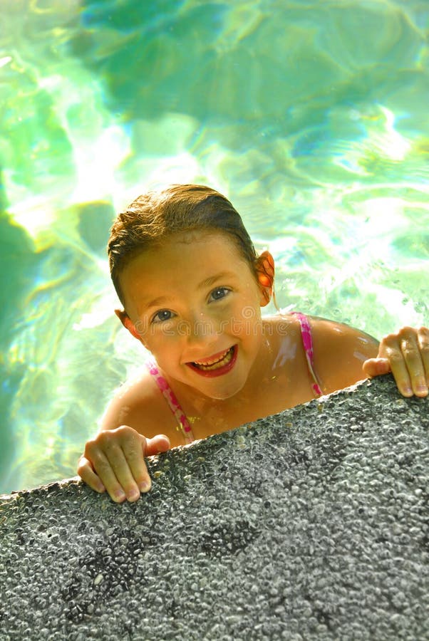 Young girl in swimming pool with wet hair