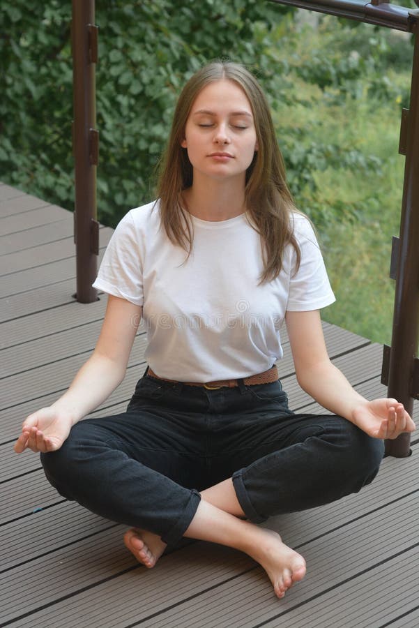 Young girl, teen ager sitting lotus position, meditating. Summer day. Education concept