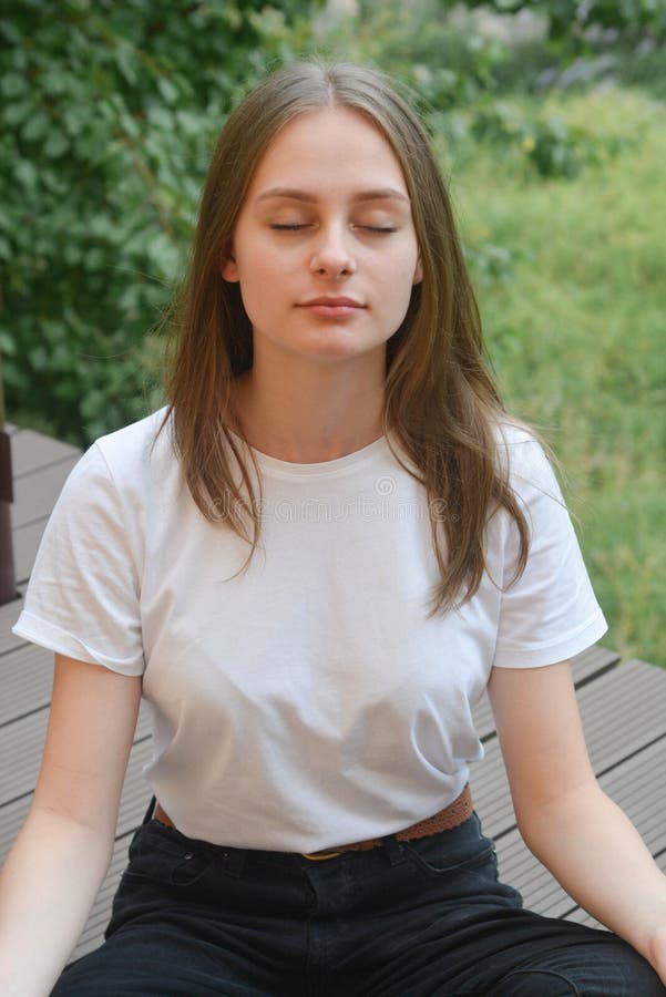 Young girl, teen ager sitting lotus position, meditating. Summer day. Education concept