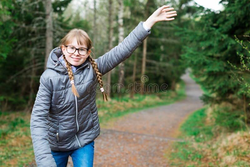 Young girl tourist in gray jacket on walking trail in th forrest stock photo Young girl tourist in gray jacket on walking trail in th forrest stock photo