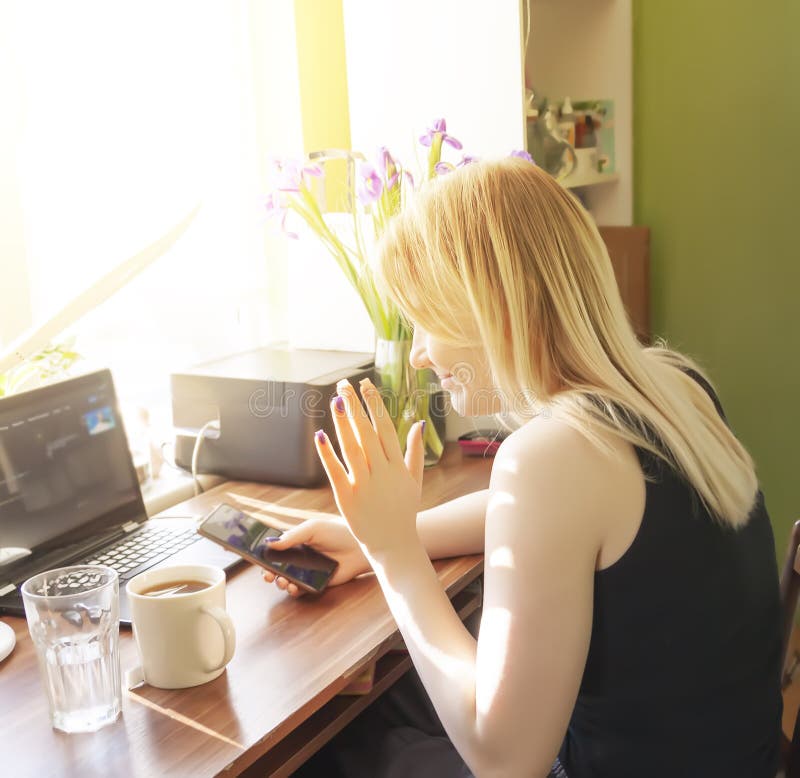 Young girl using smartphone and computer at home stock images