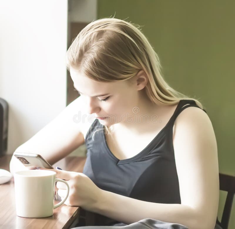 Young girl using smartphone and computer at home royalty free stock image