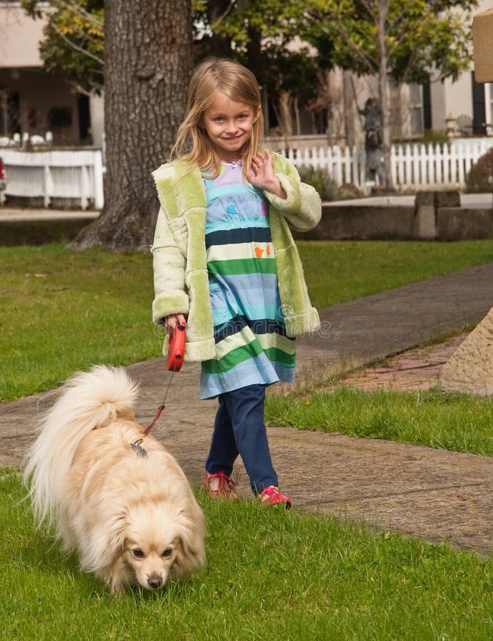 Young girl walking with little dog on a leash royalty free stock photos Young girl walking with little dog on a leash royalty free stock photos