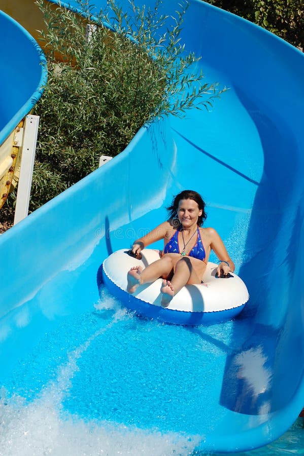 Young girl on water slide stock photos